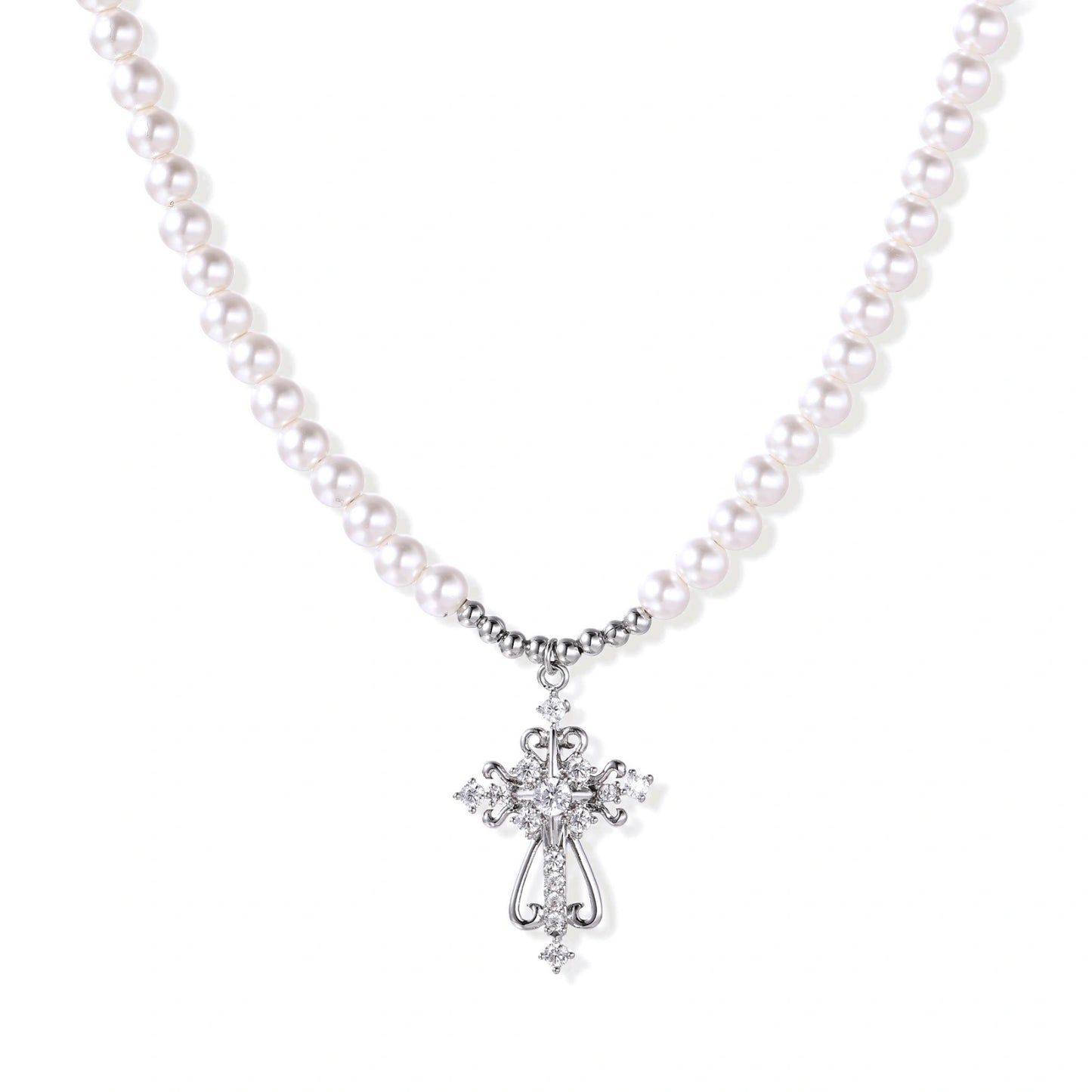 White pearl necklace with ornate silver cross pendant featuring zirconia crystals on cream background.